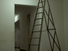 El tubo fluorescente de una sala atrancado contra la pared con una escalera